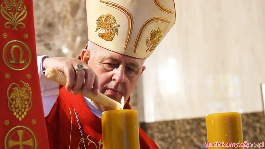 Biskup zapala świecę ołtarzową podczas poświęcenia kościoła