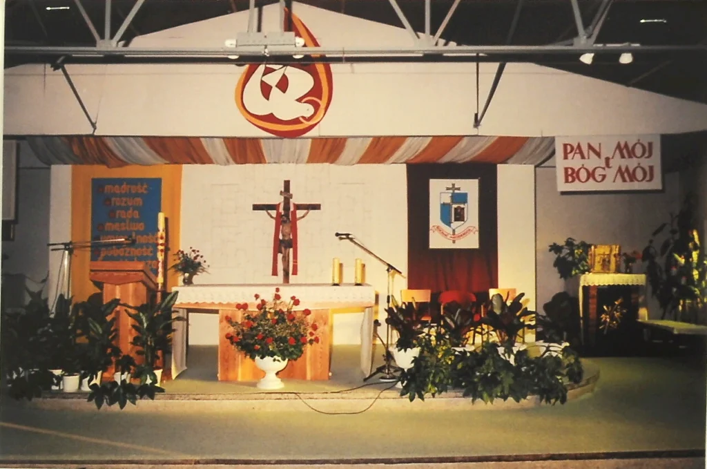 Wnętrze prowizorycznej kaplicy z ołtarzem, krzyżem i dekoracją liturgiczną